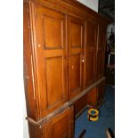 AN EARLY 19TH CENTURY SCUMBLED PINE PANELLED FOUR DOOR HOUSEKEEPERS CUPBOARD, overhanging cornice,