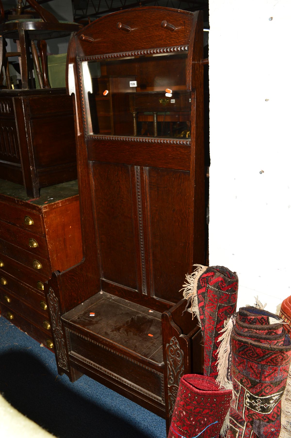 AN EARLY 20TH CENTURY OAK HALL STAND, with five assorted coat hooks, central mirror above a hinged
