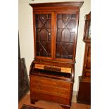 AN EDWARDIAN MAHOGANY, EBONY STRUNG AND SATINWOOD BANDED BARREL FRONT BUREAU/BOOKCASE, overhanging