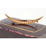 AN EARLY 20TH CENTURY GOLD SEED PEARL CRESCENT BROOCH, stamped '15c', approximate gross weight 2.0