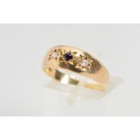 A 9CT GOLD SAPPHIRE AND DIAMOND RING, the central circular sapphire flanked by brilliant cut