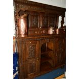 A LATE 19TH CENTURY CARVED OAK PRESS CUPBOARD/SIDEBOARD, incorporating older timbers, overhanging