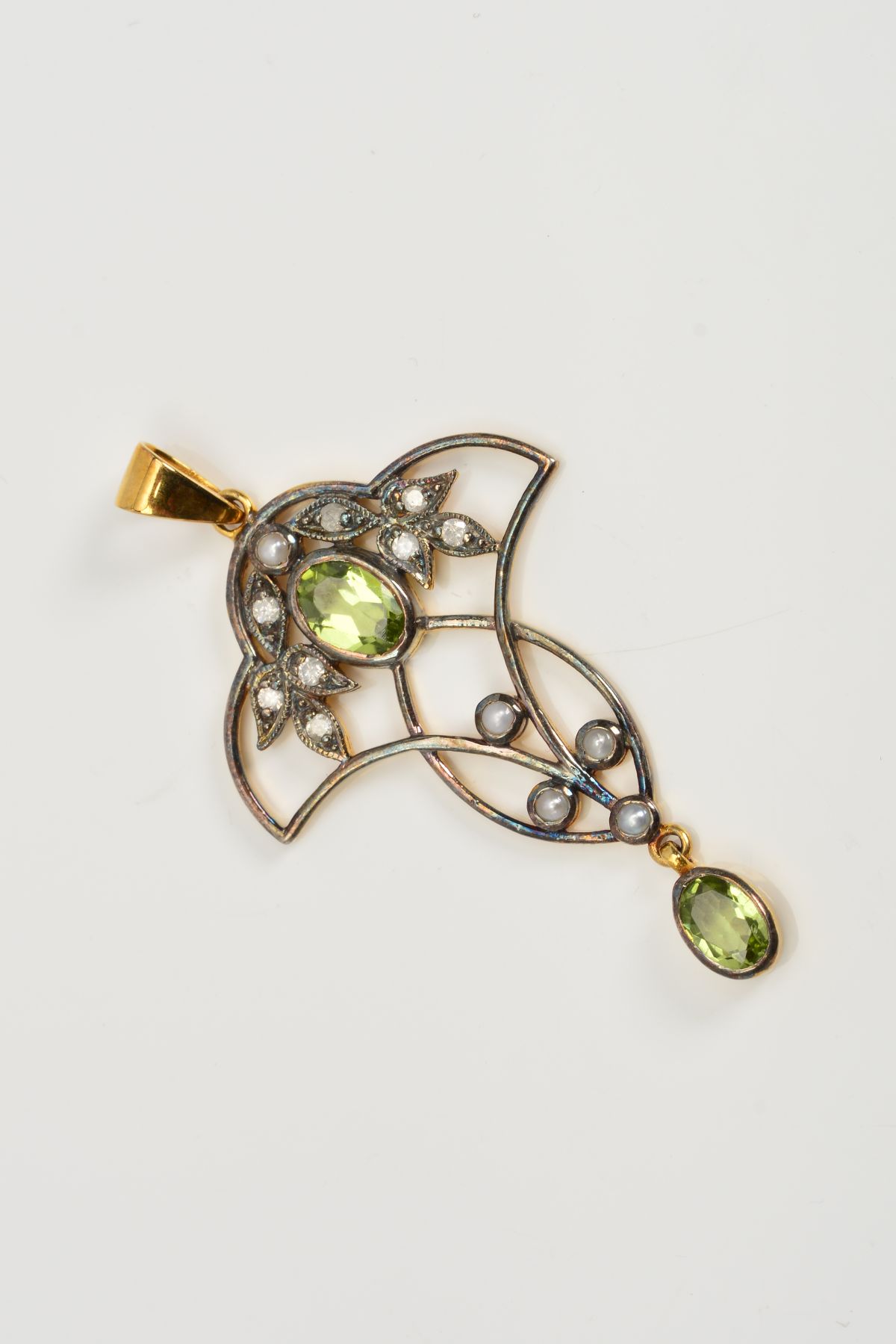 A PERIDOT, DIAMOND AND SEED PEARL PENDANT, of openwork design with a collet set peridot flanked by