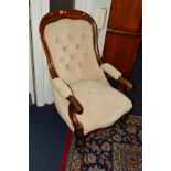 A VICTORIAN WALNUT BUTTON BACK OATMEAL UPHOLSTERED ARMCHAIR with scrolled armrests on carved front