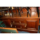 AN EDWARDIAN OAK AND MAHOGANY SIDEBOARD, short raised back with overhang, above three central