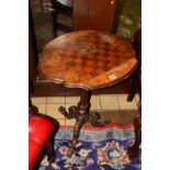AN EDWARDIAN BURR WALNUT CHESS TABLE, wavy edge on a tulip upright and scrolled tripod legs (s.d. to
