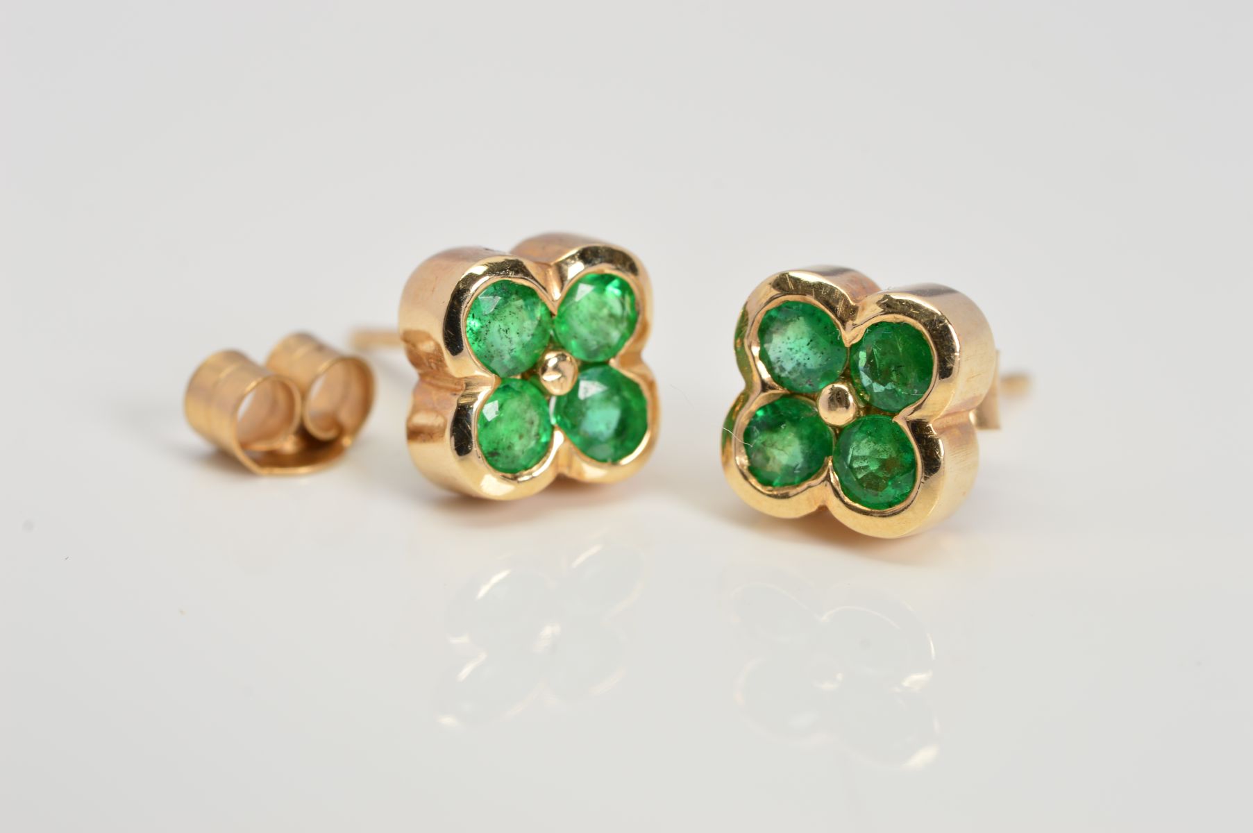 A PAIR OF 9CT GOLD EMERALD STUD EARRINGS designed as a floral cluster of four circular emeralds