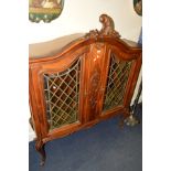 A FRENCH EARLY 20TH CENTURY OAK COLOURED LEAD GLAZED DOUBLE DOOR BOOKCASE with foliate decoration,