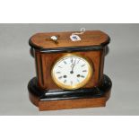 A LATE VICTORIAN WALNUT AND EBONISED MANTEL CLOCK, the shaped rectangular case with rounded ends and