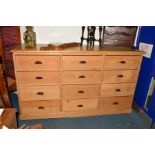 AN EARLY 20TH CENTURY PINE CHEST OF TWELVE DRAWERS/SIDEBOARD, with moulded wrought iron cupped