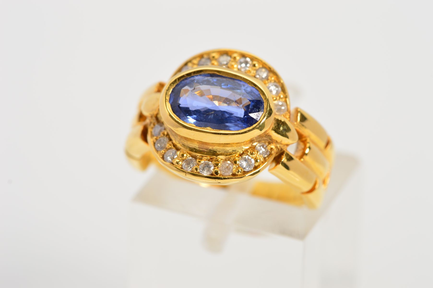 A MODERN SAPPHIRE AND DIAMOND OVAL CLUSTER RING, oval mixed cut sapphire measuring approximately 8. - Image 3 of 4