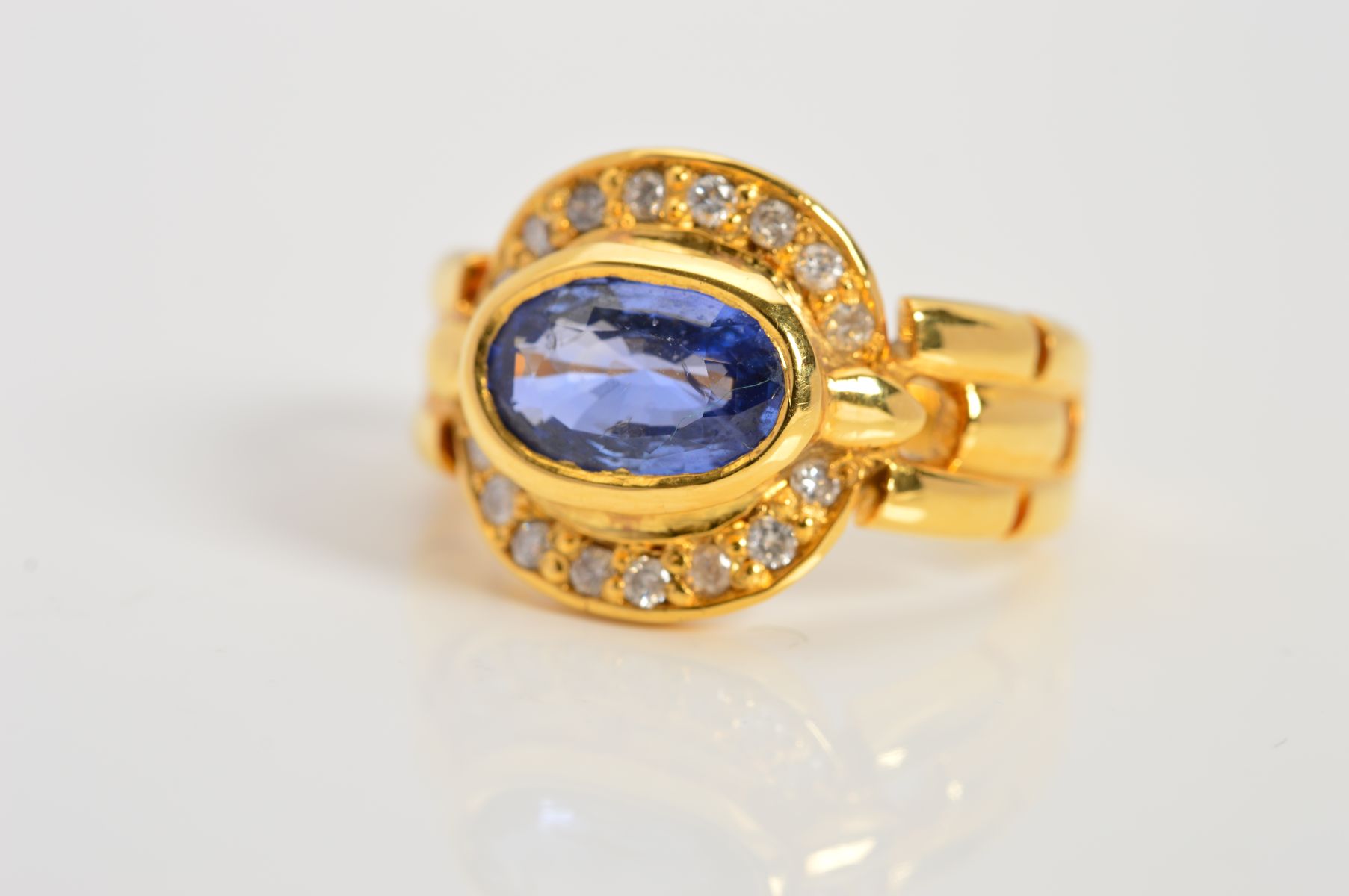 A MODERN SAPPHIRE AND DIAMOND OVAL CLUSTER RING, oval mixed cut sapphire measuring approximately 8.