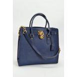 A MICHAEL KORS HAMILTON NAVY HANDBAG, the large leather tote with gold tone hardware, padlock and