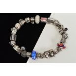 A PANDORA CHARM BRACELET, suspending twenty four charms and a safety chain, to include two glass
