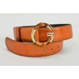 A GUCCI LEATHER BELT WITH BAMBOO BUCKLE, the belt of tan leather with a G motif buckle in gold