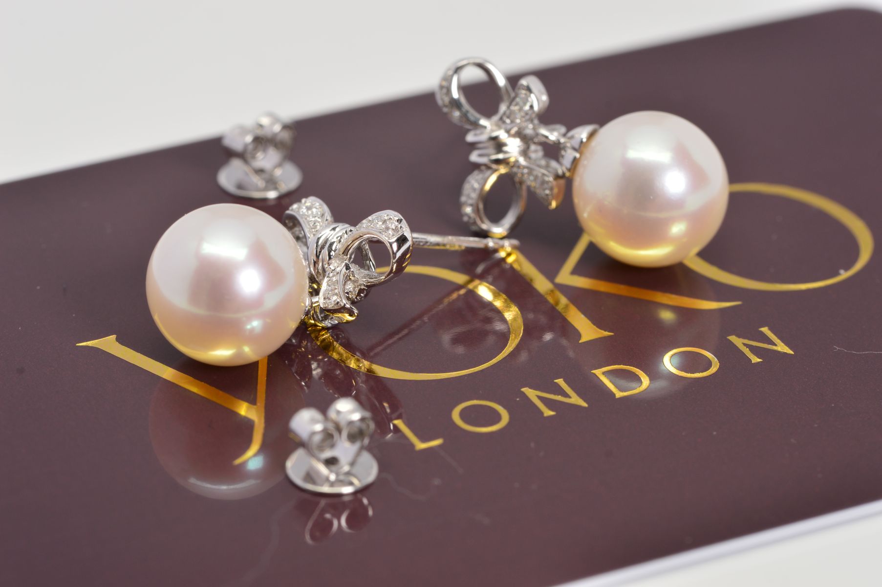 A MODERN PAIR OF YOKO 18CT WHITE GOLD CULTURED PEARL AND DIAMOND BOW DESIGN DROP EARRINGS,