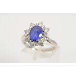 A MODERN 18CT WHITE GOLD TANZANITE AND DIAMOND OVAL CLUSTER RING, oval mixed cut tanzanite measuring