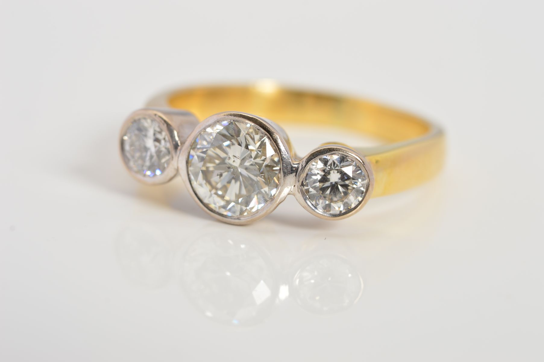 AN 18CT GOLD THREE STONE DIAMOND RING, designed as three brilliant cut diamonds within collet