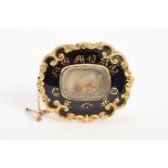 A MID VICTORIAN MEMORIAL BROOCH, the central glass panel encasing an arranged lock of hair with