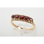 A 9CT GOLD GARNET RING, designed as a graduated row of five circular garnets to the scrolling