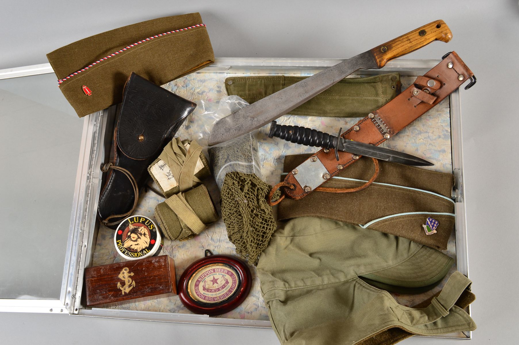 A LARGE GLASS TOP DEALER STYLE DISPLAY CASE CONTAINING THE FOLLOWING MILITARY ITEMS, WWII era or