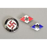 THREE GERMAN 3RD REICH METAL AND ENAMEL BADGES, two Hitler Youth and a Heim Ins Reich badge, all