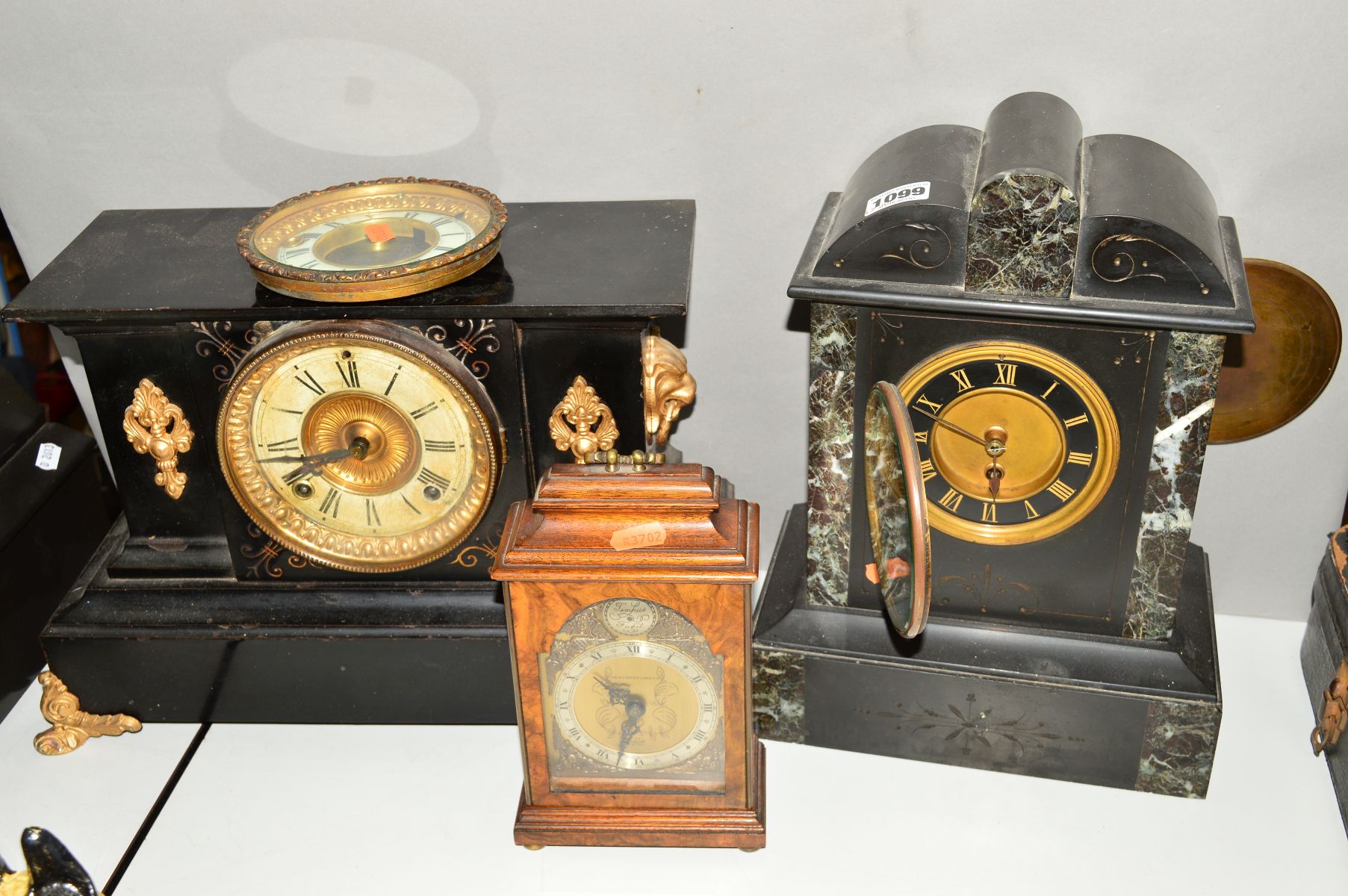 A BLACK SLATE AND MARBLE MANTLE CLOCK WITH A BLACK AND GILT FACE AND ROMAN NUMERAL MARKERS, together