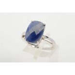 A 9CT WHITE GOLD SAPPHIRE RING, designed as a curved rectangular sapphire within a four claw setting