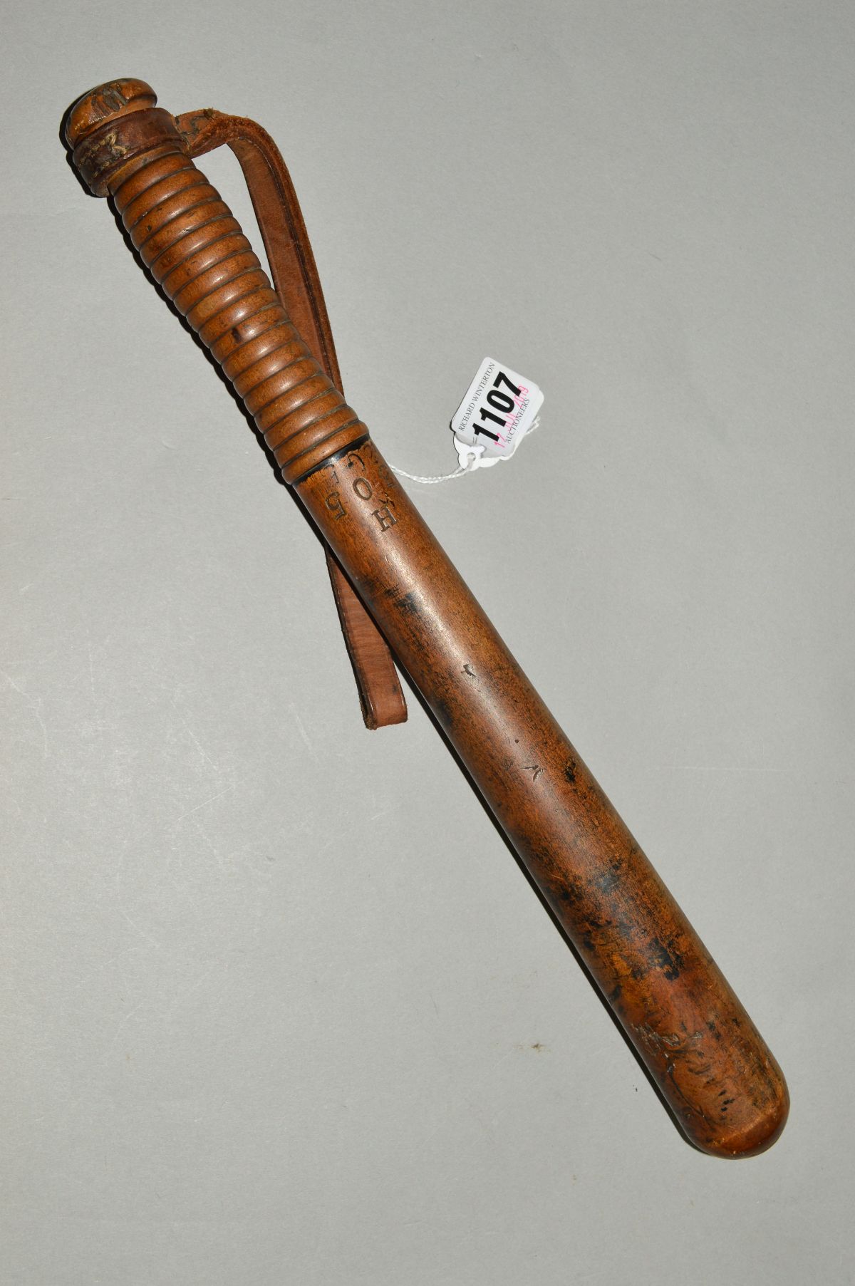 A MILITARY TRUNCHEON with leather wrist strap, broad arrow stamped into the shaft, approximate