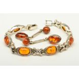 A MODIFIED AMBER BRACELET AND PAIR OF EARRINGS, the bracelet designed as modified amber cabochon