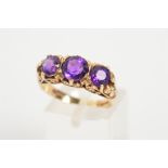 A 9CT GOLD AMETHYST THREE STONE RING, designed as three graduated circular amethysts to the
