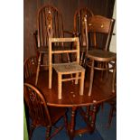 AN OAK DROP LEAF TABLE, together with six wheel back oak chairs and two others (9)