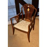 AN EDWARDIAN MAHOGANY AND IVORY STRUNG ELBOW CHAIR, the shaped back with central flower head