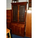 AN EDWARDIAN MAHOGANY GLAZED BOOKCASE above two drawers and double cupboard doors, width 107cm x