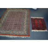 A 20TH CENTURY WILTON STYLE RUG, red, glue and cream, 180cm x 126cm and a red ground kneeling