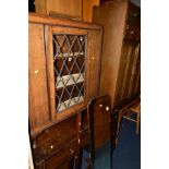 AN OAK LEAD GLAZED SINGLE DOOR BOOKCASE, together with an oak tall boy, oak desk and a cheval mirror