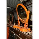 A VICTORIAN WALNUT OVAL TOILET MIRROR, together with a similar mahogany toilet mirror and another