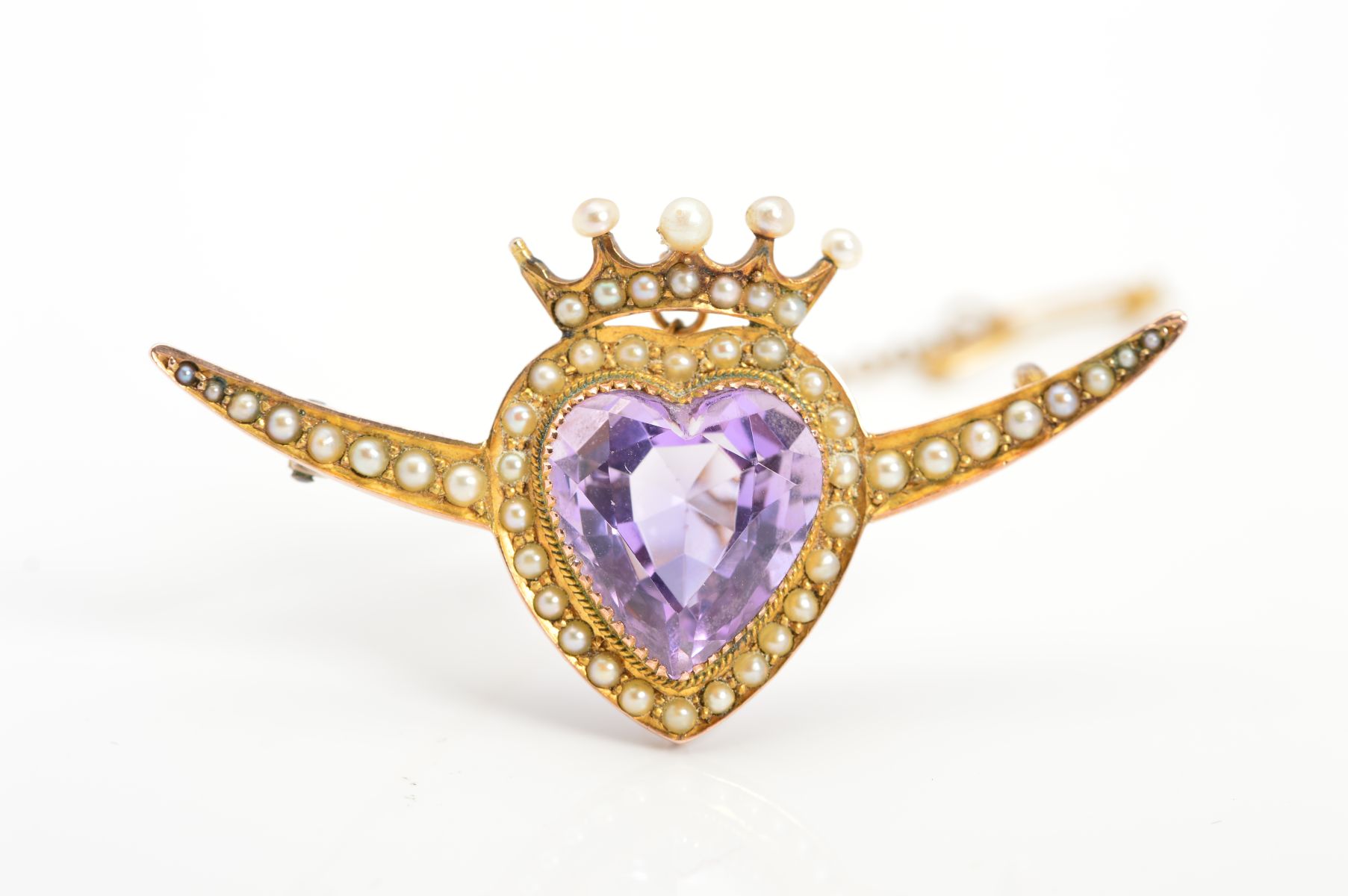 AN EARLY 20TH CENTURY 9CT GOLD AMETHYST AND SEED PEARL HEART BROOCH, the central amethyst heart