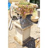 A LARGE CIRCULAR STONE PLANTER, lattice perimeter on a seperate base supported on a square composite