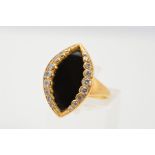 AN 18CT GOLD ONYX AND DIAMOND RING, designed as a marquise shape onyx panel bordered to each side
