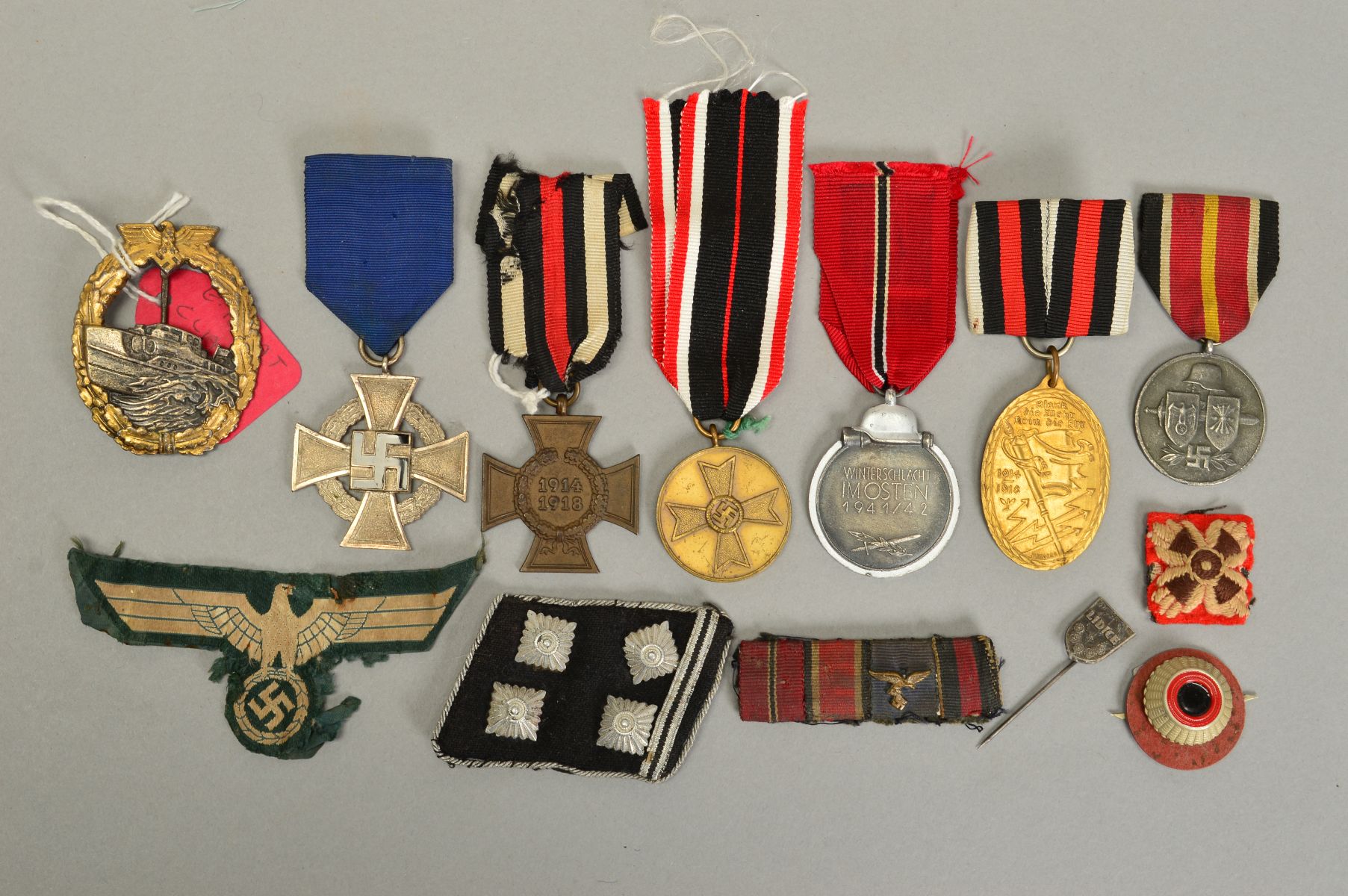 A TRAY CONTAINING A NUMBER OF WWI AND WWII ITEMS, from German forces to include WWII Russian