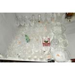 A QUANTITY OF GLASSWARE, including four decanters, vases, drinking glasses, paperweights, pedestal