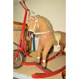 A WOODEN ROCKING HORSE, plush covered, fabric mane and tail, painted wooden mouth and hooves,