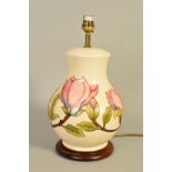 A MOORCROFT POTTERY TABLE LAMP, 'Magnolia' pattern on cream ground, on wooden plinth, total height