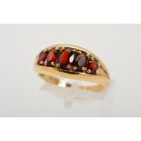 A 9CT GOLD GARNET DRESS RING, designed as a line of five graduated oval garnets with 9ct gold