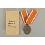A WWII GERMAN WEST WALL MEDAL, with ribbon and an issue envelope indicating the maker 'Carl