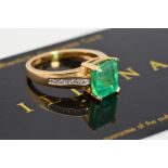 AN 18CT GOLD EMERALD AND DIAMOND RING, the central rectangular emerald within a four claw setting to