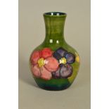 A MOORCROFT POTTERY BUD VASE, 'Clematis' pattern on green ground, impressed marks to base, height