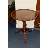 A REPRODUCTION MAHOGANY CIRCULAR TRIPOD TABLE, with a wavy top edge