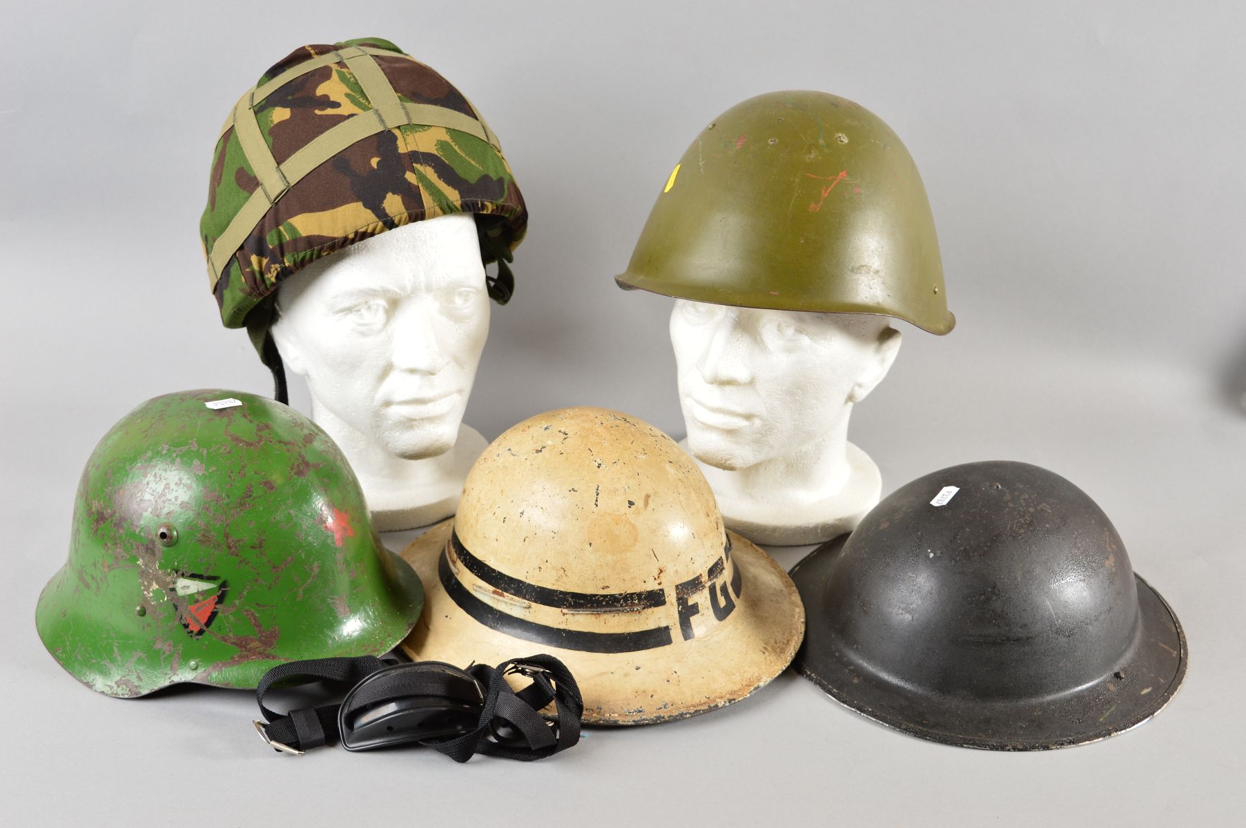 A BOX CONTAINING FIVE MILITARY HELMETS, as follows, Post War WWII era Eastern Block helmet, green